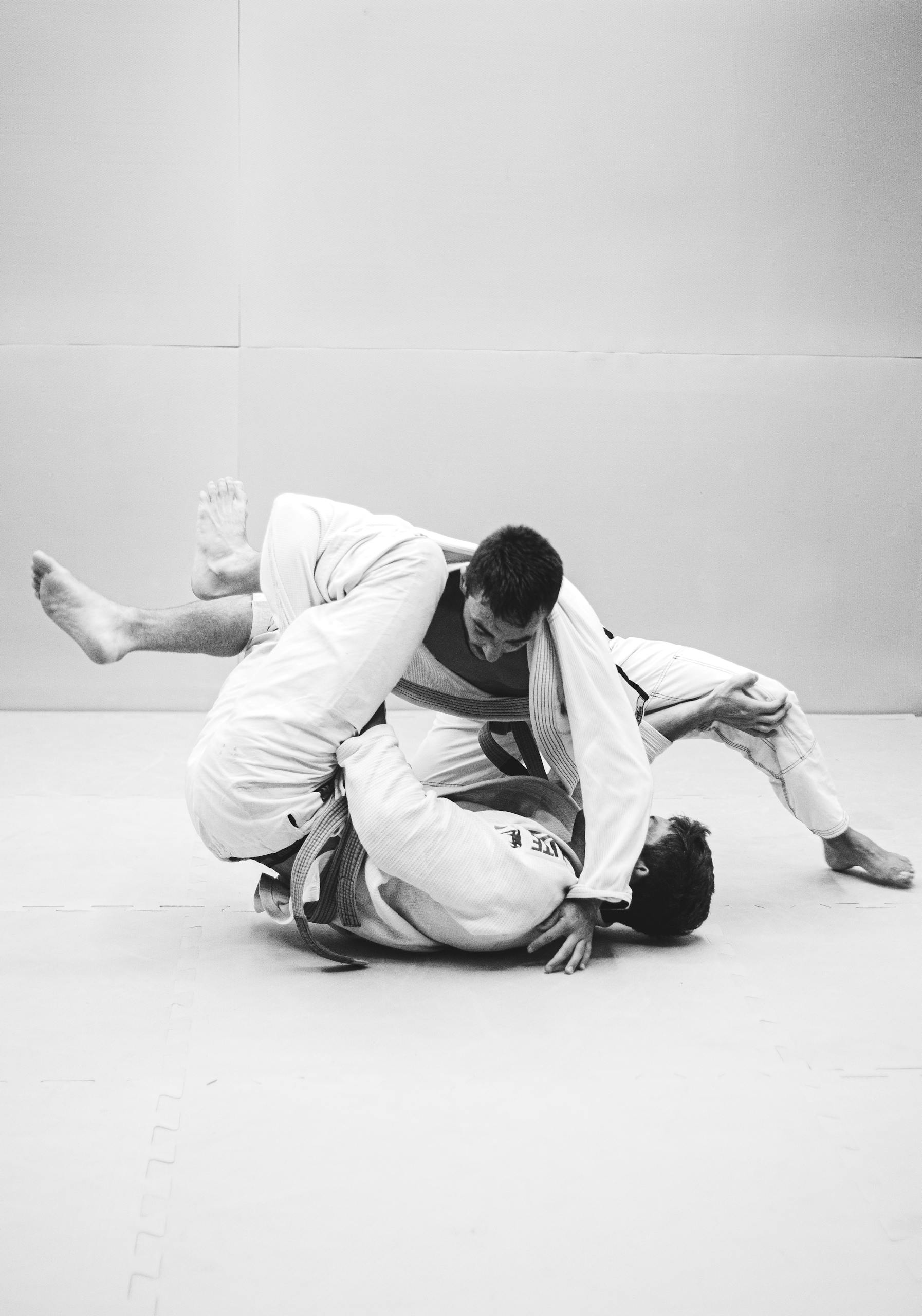 Two men practicing Brazilian Jiu-Jitsu, showcasing technique and skill.